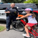 Reading Police Officer Kaylyn Balbo presents a citation to a girl who was seen riding her bike with a helmet on. (Courtesy Reading Police Department)